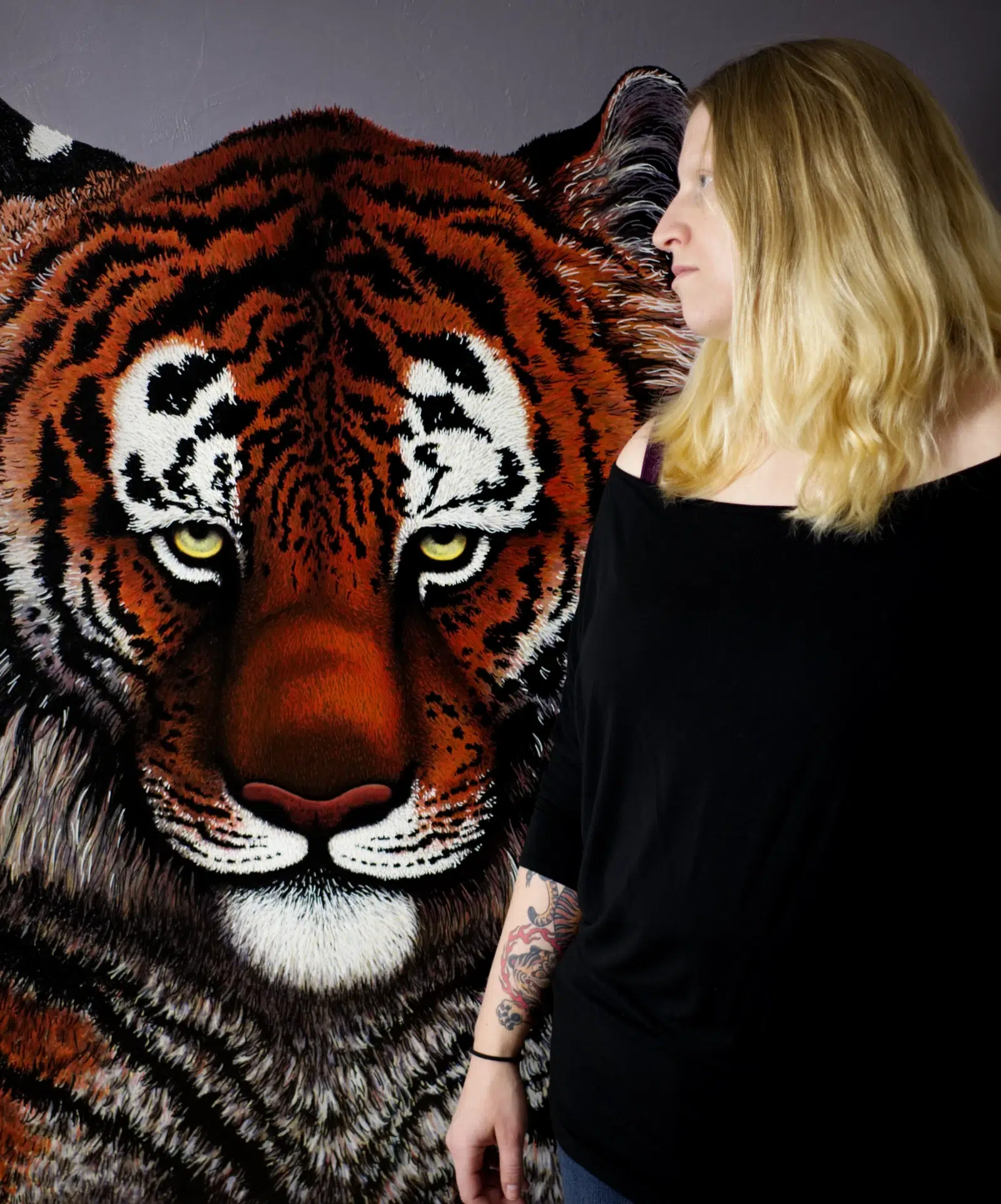 A photo portrait of the artist in front of I Don't Want To Live In A World Without Tigers in progress.